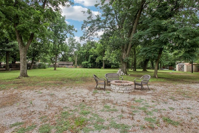 9228 E Cardinal Pl, Midwest City, OK 73130 - view of green lawn with a shed, an outdoor fire pit, and view of wooded area
