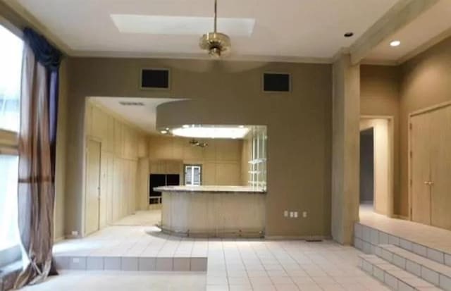 5720 Irvine Dr, Edmond, OK 73025 - unfurnished living room with healthy amount of natural light, light tile patterned floors, ornamental molding, and recessed lighting