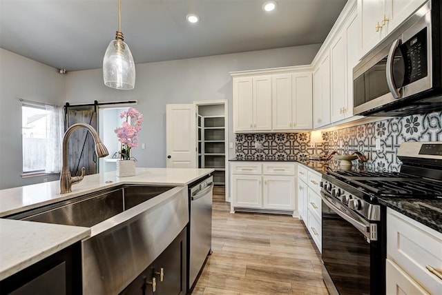 9021 NW 74th St, Yukon, OK 73099 - kitchen featuring stainless steel appliances, white cabinetry, hanging light fixtures, tasteful backsplash, and recessed lighting