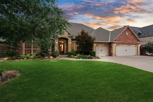 1008 Trisha Ln, Norman, OK 73072 - view of front of home featuring a lawn, an attached garage, a shingled roof, and concrete driveway