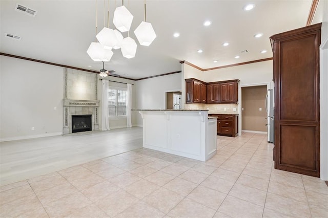 1008 Trisha Ln, Norman, OK 73072 - kitchen with crown molding, a kitchen bar, a peninsula, ceiling fan, and open floor plan