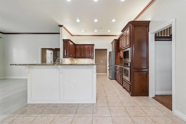 1008 Trisha Ln, Norman, OK 73072 - kitchen with appliances with stainless steel finishes, a breakfast bar area, stone countertops, decorative backsplash, and crown molding