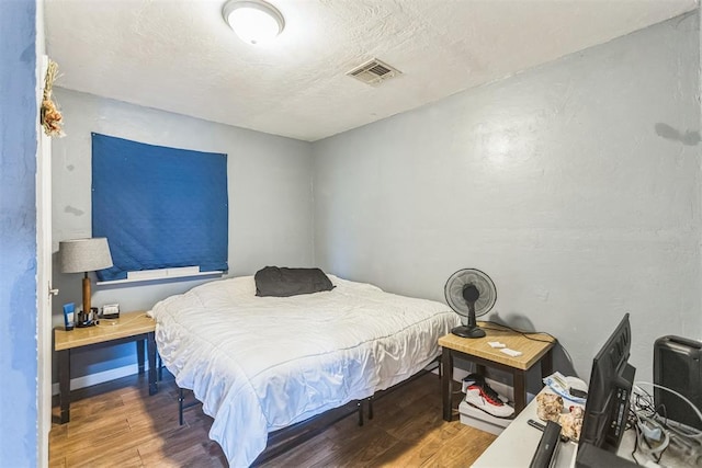 321 W 1st St, Wewoka, OK 74884 - bedroom with wood finished floors and a textured ceiling