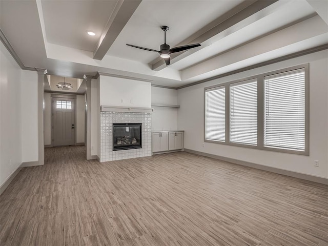 6609 NW 147th St, Oklahoma City, OK 73142 - unfurnished living room with light wood finished floors, ceiling fan, a raised ceiling, a brick fireplace, and beam ceiling