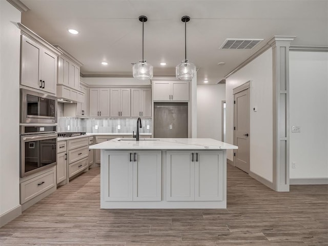 6609 NW 147th St, Oklahoma City, OK 73142 - kitchen with appliances with stainless steel finishes, backsplash, light wood-style floors, recessed lighting, and an island with sink