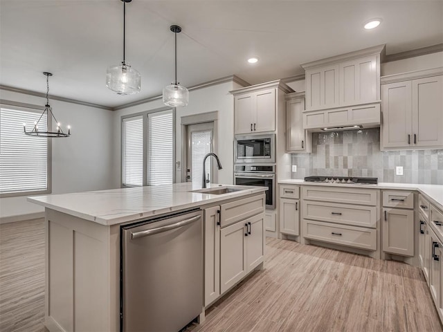 6609 NW 147th St, Oklahoma City, OK 73142 - kitchen featuring stainless steel appliances, ornamental molding, a center island with sink, decorative backsplash, and light wood-type flooring