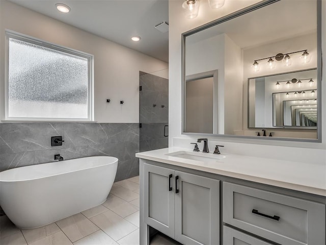 6609 NW 147th St, Oklahoma City, OK 73142 - bathroom with a soaking tub, vanity, a shower stall, tile walls, and tile patterned floors