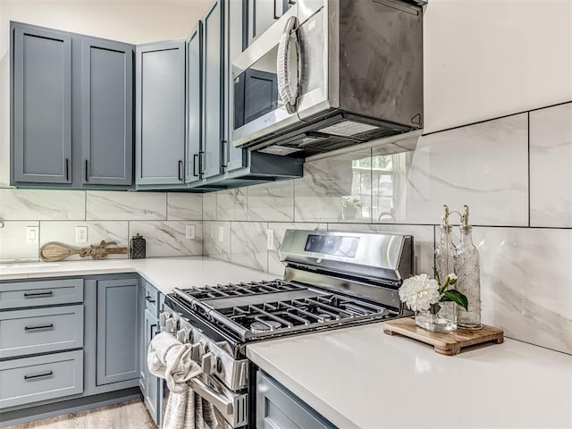 1800 NW 41st St, Oklahoma City, OK 73118 - kitchen featuring stainless steel appliances, gray cabinets, decorative backsplash, and light countertops