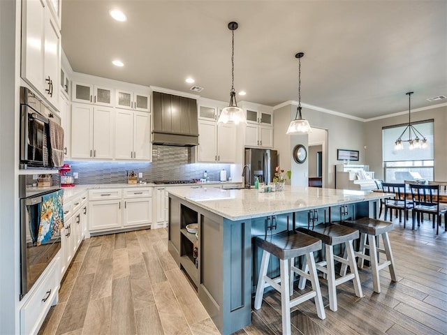 4000 Timber Creek Way, Moore, OK 73165 - kitchen featuring stainless steel appliances, tasteful backsplash, white cabinets, a large island, and decorative light fixtures