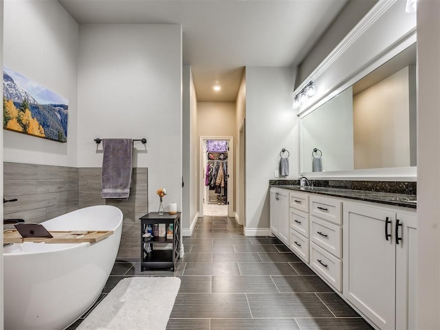 4000 Timber Creek Way, Moore, OK 73165 - full bath with double vanity, a freestanding bath, a spacious closet, tile walls, and wainscoting