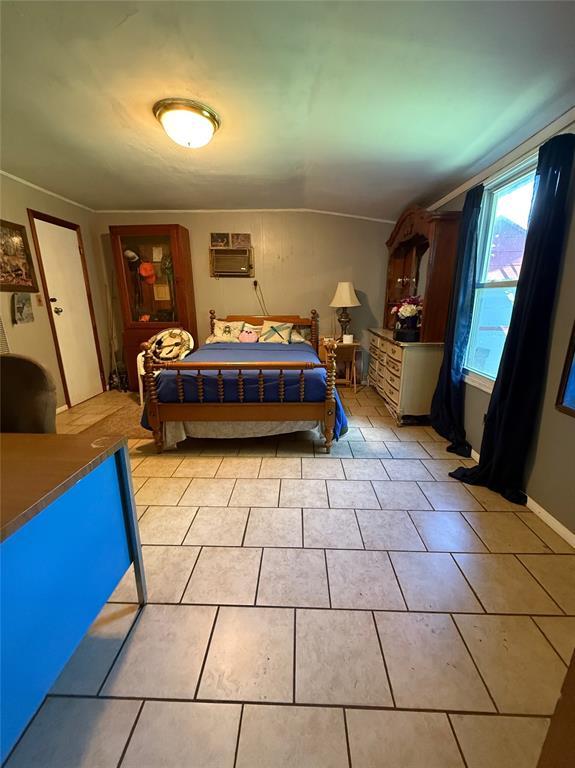 808 Oakdale Dr, Oklahoma City, OK 73127 - bedroom featuring a wall mounted air conditioner and light tile patterned floors