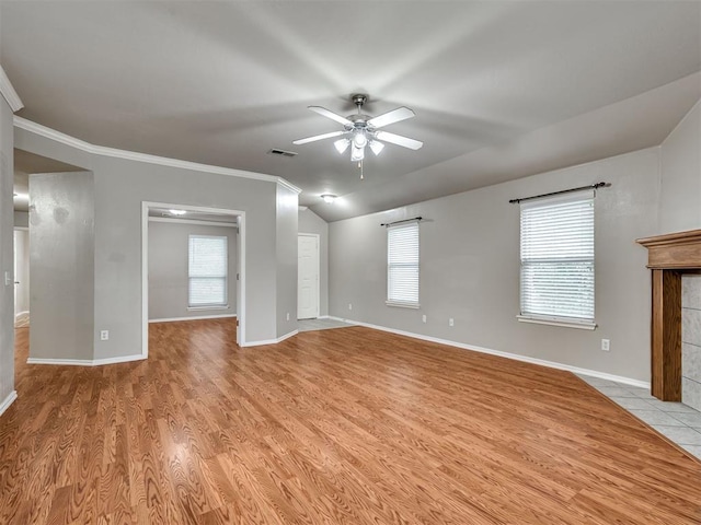 10808 Cheshire Ct, Yukon, OK 73099 - unfurnished living room with a ceiling fan, ornamental molding, light wood-style flooring, plenty of natural light, and vaulted ceiling