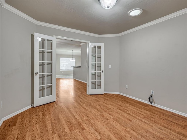 10808 Cheshire Ct, Yukon, OK 73099 - spare room with french doors, light wood-style floors, crown molding, and a chandelier