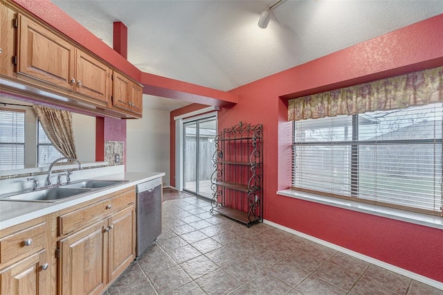 1709 Rocky Mountain Way, Edmond, OK 73003 - kitchen featuring dishwasher, light countertops, plenty of natural light, a textured wall, and brown cabinets