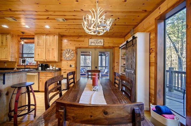 123 Hemlock Grove Rd, Hochatown, OK 74728 - dining space with french doors, wood finished floors, wood walls, a chandelier, and wooden ceiling