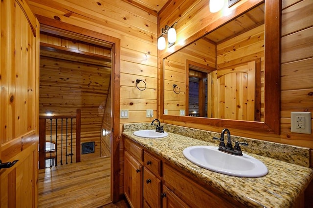 123 Hemlock Grove Rd, Hochatown, OK 74728 - full bathroom featuring wooden walls, double vanity, and wood finished floors