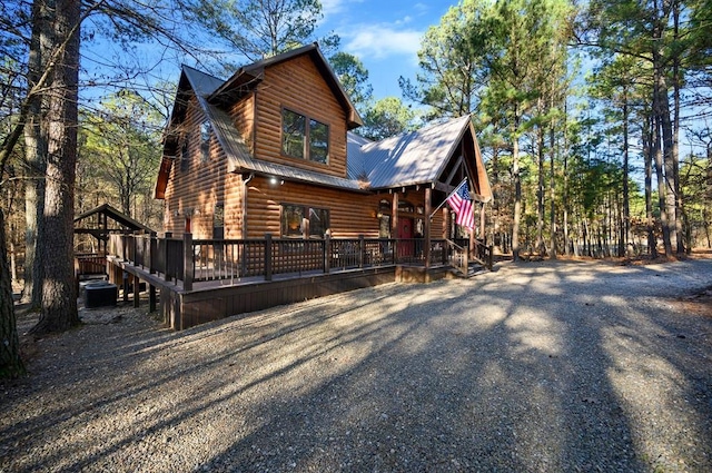 123 Hemlock Grove Rd, Hochatown, OK 74728 - view of front facade featuring faux log siding, a deck, and a metal roof