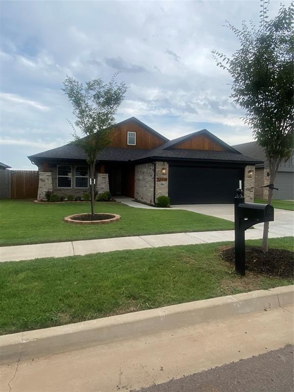 12616 NW 4th St, Yukon, OK 73099 - view of front of property featuring an attached garage, concrete driveway, and stone siding