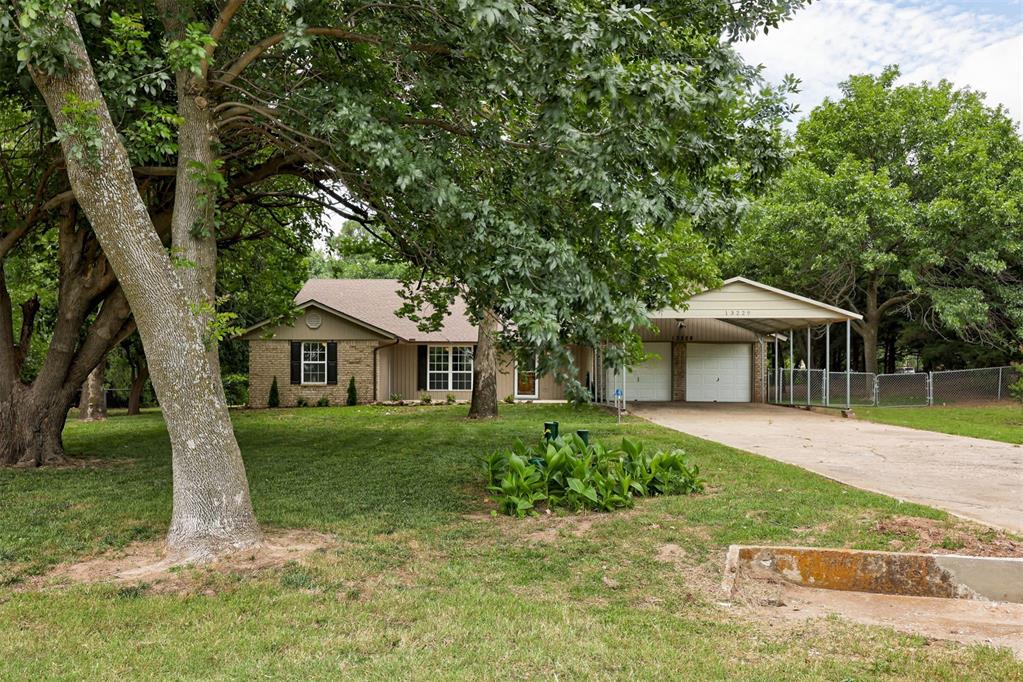 13229 Blue Quail Rd, Yukon, OK 73099 - ranch-style house with a garage, driveway, brick siding, and a carport