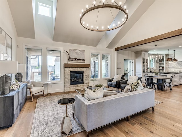 7308 Sunset Sail Ave, Edmond, OK 73034 - living area featuring a chandelier, high vaulted ceiling, plenty of natural light, a fireplace, and light wood-style floors