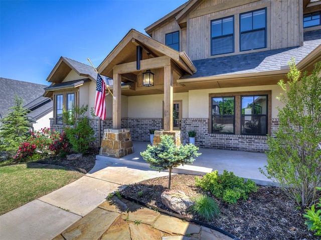 7308 Sunset Sail Ave, Edmond, OK 73034 - view of front facade with brick siding, stucco siding, a shingled roof, and a porch