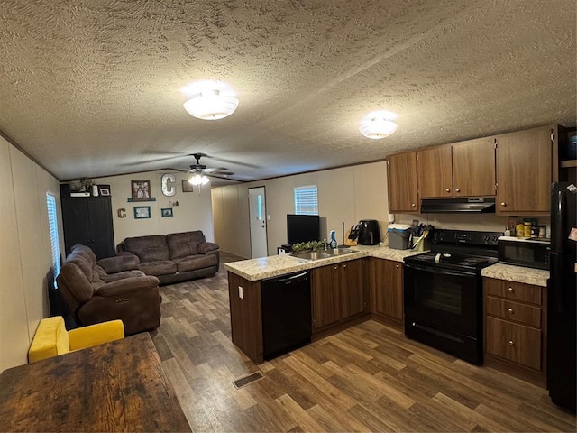 330633 E 875th Rd, Wellston, OK 74881 - kitchen featuring black appliances, under cabinet range hood, dark wood finished floors, a peninsula, and light countertops