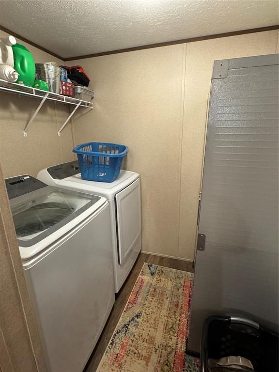 330633 E 875th Rd, Wellston, OK 74881 - laundry room with washer and dryer, wood finished floors, and a textured ceiling