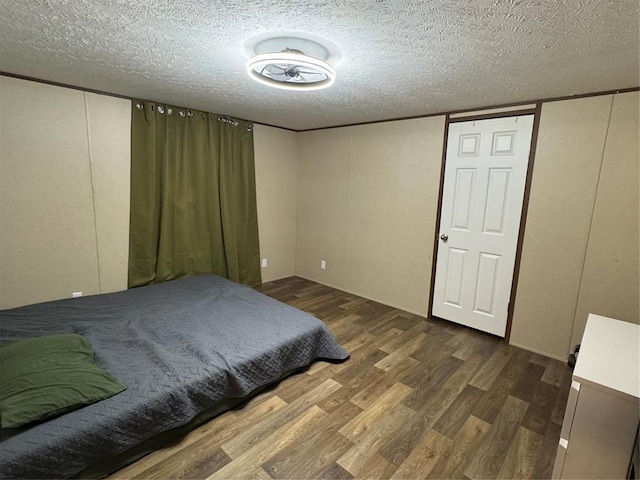 330633 E 875th Rd, Wellston, OK 74881 - bedroom featuring wood finished floors, a textured ceiling, and a decorative wall