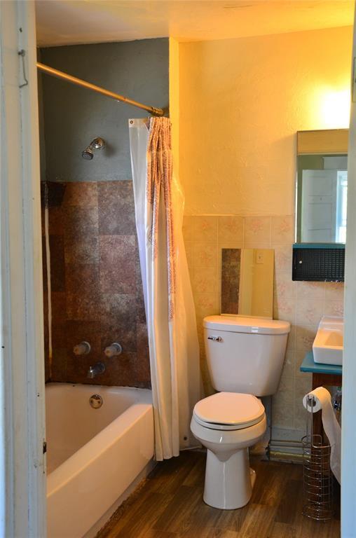 120 S Chickasaw Ave, Bartlesville, OK 74003 - bathroom featuring wood finished floors, shower / bath combo, vanity, and tile walls