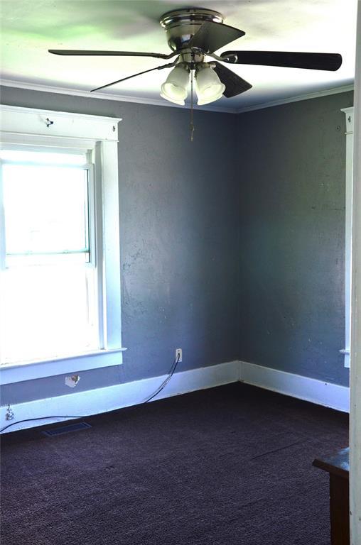 120 S Chickasaw Ave, Bartlesville, OK 74003 - unfurnished room featuring dark colored carpet, a ceiling fan, and ornamental molding
