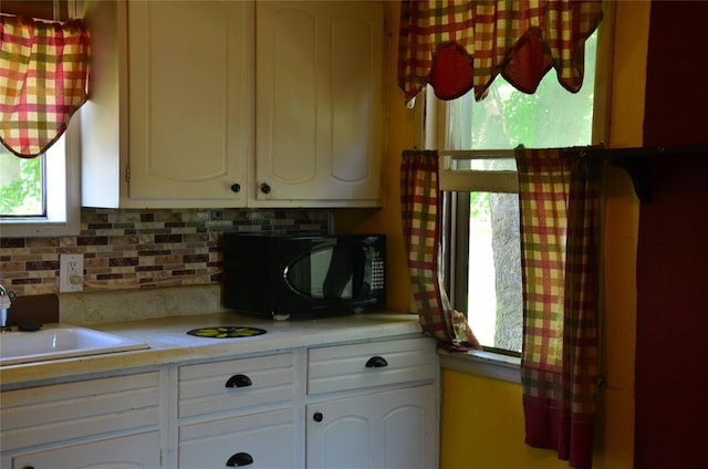 120 S Chickasaw Ave, Bartlesville, OK 74003 - kitchen with black microwave, light countertops, and plenty of natural light
