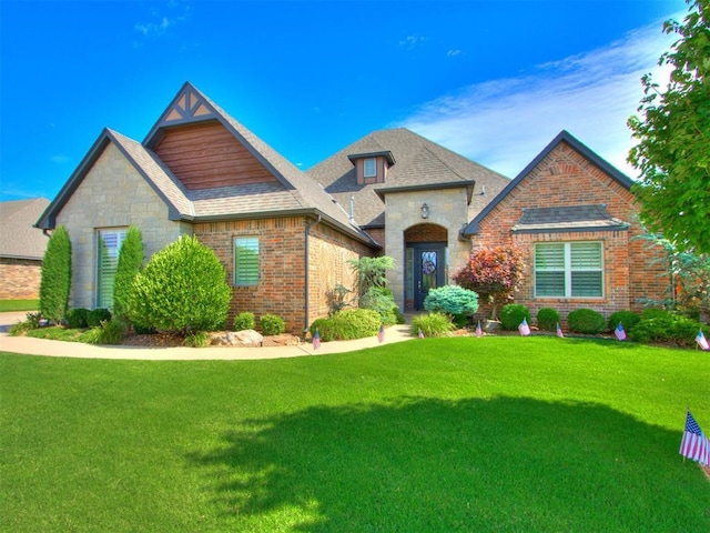 13308 NW 6th St, Yukon, OK 73099 - view of front of home with a front yard, brick siding, stone siding, and a shingled roof