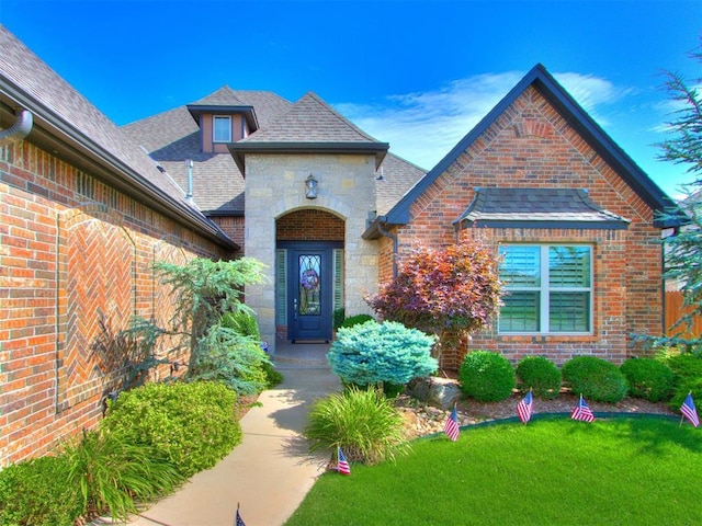 13308 NW 6th St, Yukon, OK 73099 - property entrance featuring brick siding, stone siding, and roof with shingles