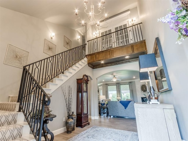 13308 NW 6th St, Yukon, OK 73099 - entrance foyer featuring wood finished floors, arched walkways, stairway, a ceiling fan, and a high ceiling