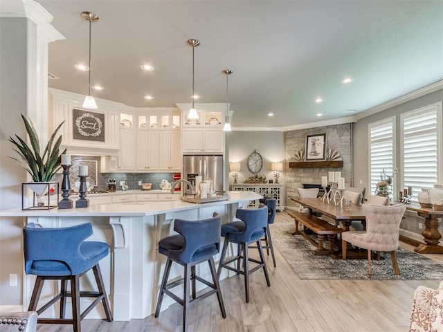 13308 NW 6th St, Yukon, OK 73099 - kitchen featuring stainless steel fridge, ornamental molding, tasteful backsplash, light countertops, and glass insert cabinets