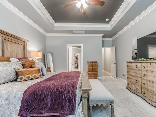 13308 NW 6th St, Yukon, OK 73099 - bedroom featuring a raised ceiling, light colored carpet, ornamental molding, ceiling fan, and a walk in closet