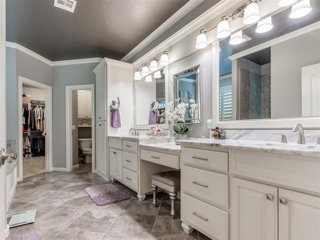13308 NW 6th St, Yukon, OK 73099 - bathroom featuring vanity, ornamental molding, and a walk in closet