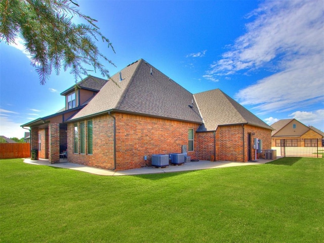 13308 NW 6th St, Yukon, OK 73099 - back of house featuring a patio, brick siding, roof with shingles, and a fenced backyard