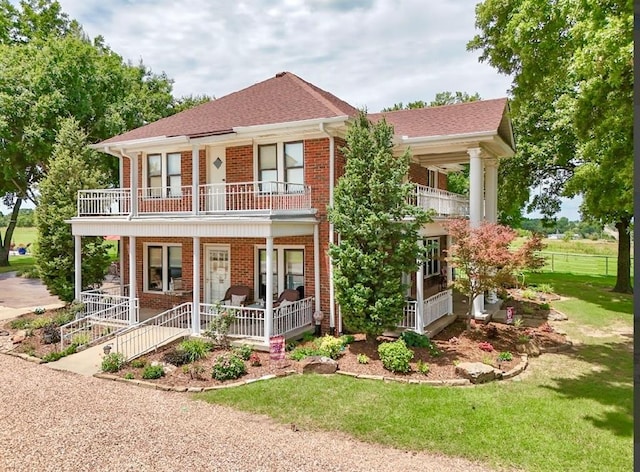 13902 Valley View Rd, Shawnee, OK 74804 - view of front facade featuring a balcony, brick siding, covered porch, a front lawn, and roof with shingles