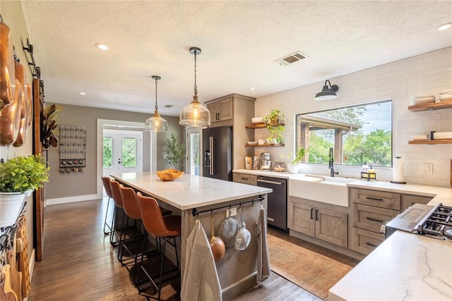 19277 E 1220th Rd, Sayre, OK 73662 - kitchen with open shelves, stainless steel appliances, a textured ceiling, wood finished floors, and a center island