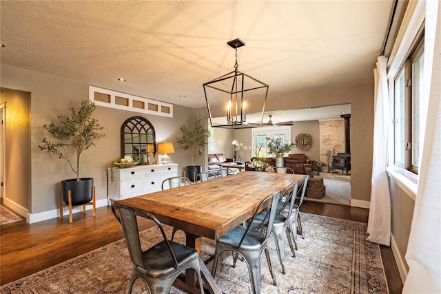 19277 E 1220th Rd, Sayre, OK 73662 - dining space featuring dark wood-style floors, a wood stove, and a chandelier