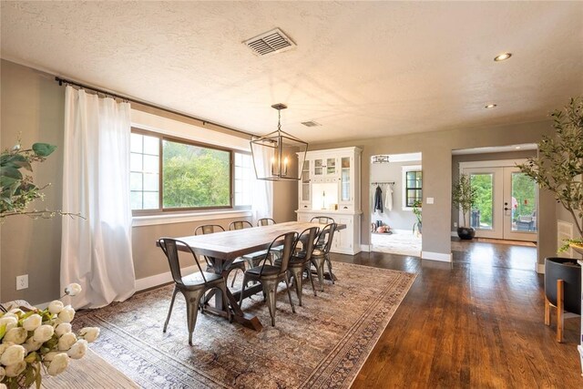 19277 E 1220th Rd, Sayre, OK 73662 - dining area with dark wood-type flooring, healthy amount of natural light, a chandelier, french doors, and a textured ceiling