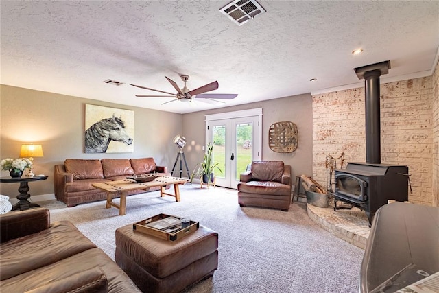 19277 E 1220th Rd, Sayre, OK 73662 - living room featuring a wood stove, carpet flooring, a ceiling fan, a textured ceiling, and french doors