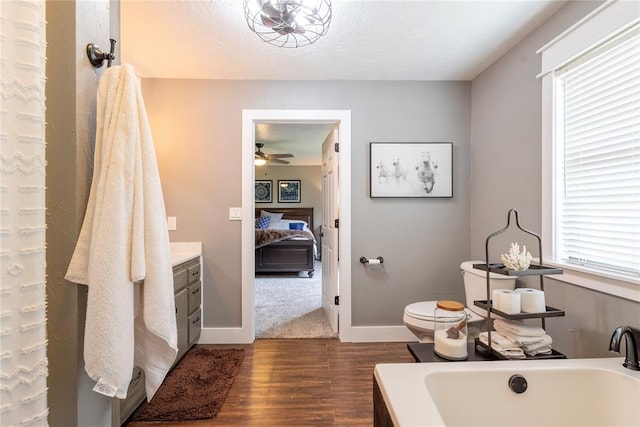 19277 E 1220th Rd, Sayre, OK 73662 - full bathroom with a tub, ensuite bathroom, wood finished floors, vanity, and a ceiling fan