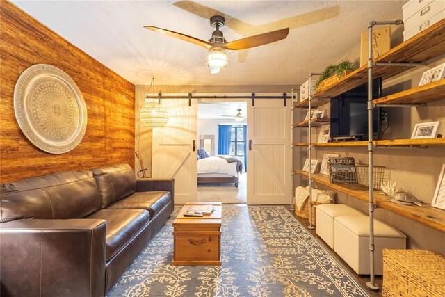 19277 E 1220th Rd, Sayre, OK 73662 - living area featuring a barn door, ceiling fan, and carpet floors