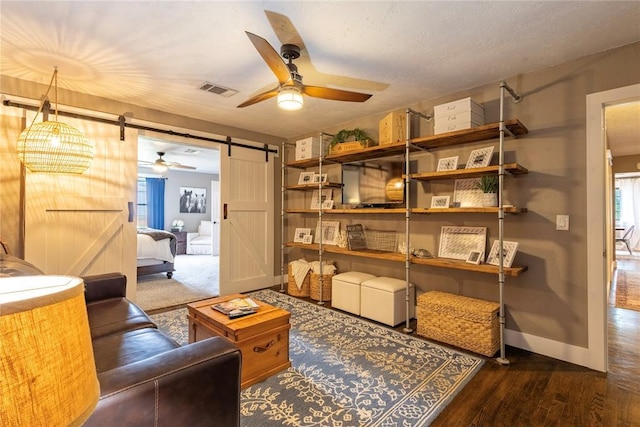 19277 E 1220th Rd, Sayre, OK 73662 - living area with a barn door, a ceiling fan, and wood finished floors