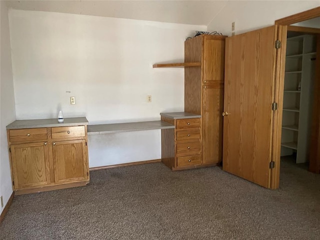 1333 Reid St, Seminole, OK 74868 - kitchen with built in study area, dark carpet, brown cabinetry, and open shelves