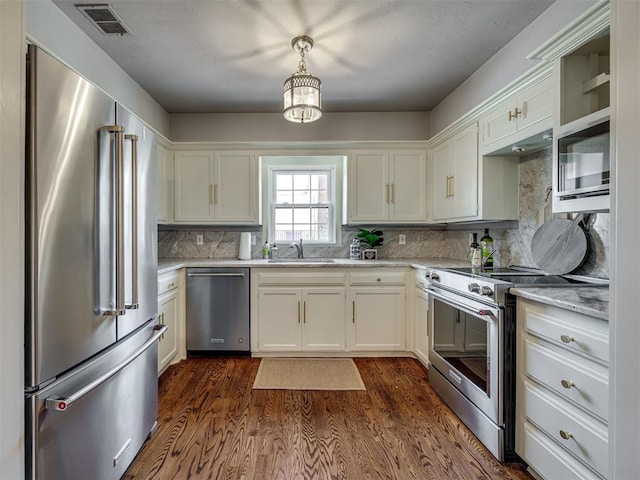 6432 Brandywine Ln, Oklahoma City, OK 73116 - kitchen featuring appliances with stainless steel finishes, decorative backsplash, white cabinets, and dark wood-style flooring