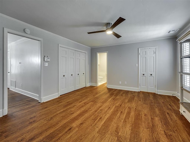 6432 Brandywine Ln, Oklahoma City, OK 73116 - unfurnished bedroom featuring ornamental molding, wood finished floors, multiple closets, a ceiling fan, and ensuite bath