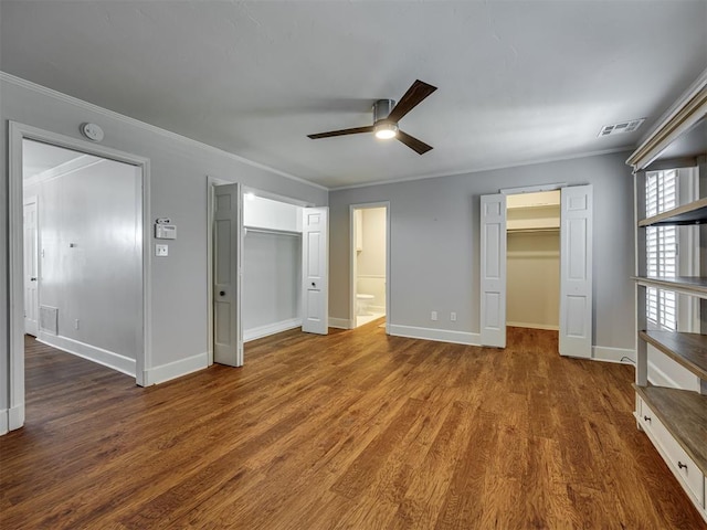 6432 Brandywine Ln, Oklahoma City, OK 73116 - unfurnished bedroom with a spacious closet, crown molding, wood finished floors, a closet, and a ceiling fan